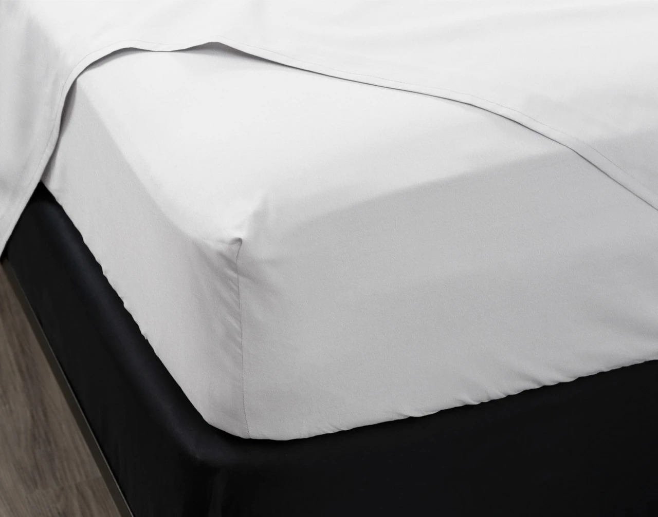 A bedroom with a queen bed made up in QE Home bedding